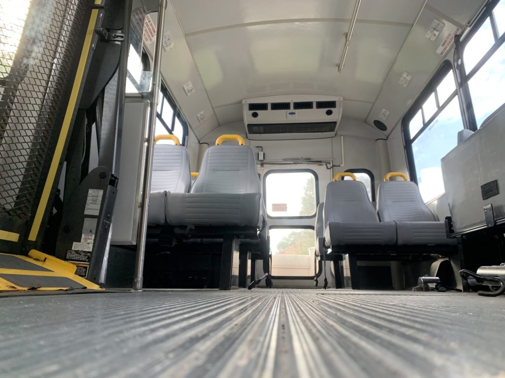 Empty bus interior with seats and aisle view.
