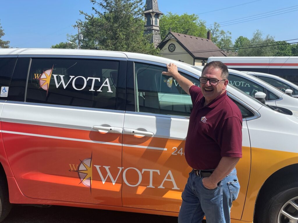 Man smiling by a WOTA branded van