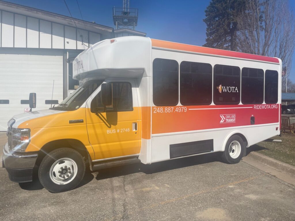 Yellow and white Oakland Transit bus parked outdoors